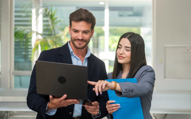 HR vs Hiring Manager_ quando la selezione parla due lingue diverse Una consulente HR e un hiring manager collaborano analizzando i dati dei candidati su un laptop in ufficio.